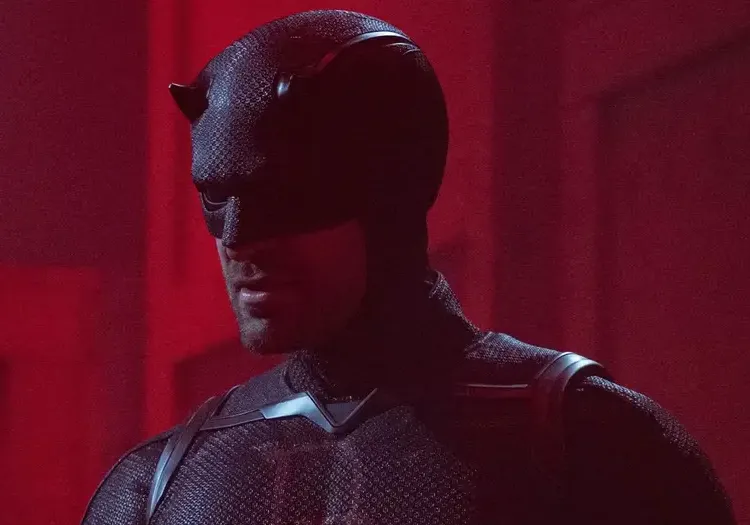 Daredevil in his black suit standing against a red background